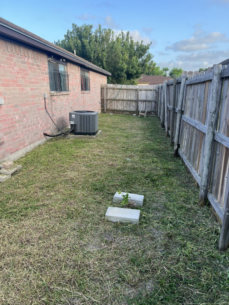 Total lawn makeover and cleanup completed, resulting in a neat, well-maintained yard. (After image)